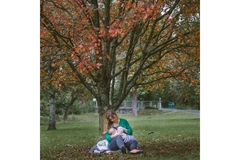 Woman nursing her infant sitting in the park
